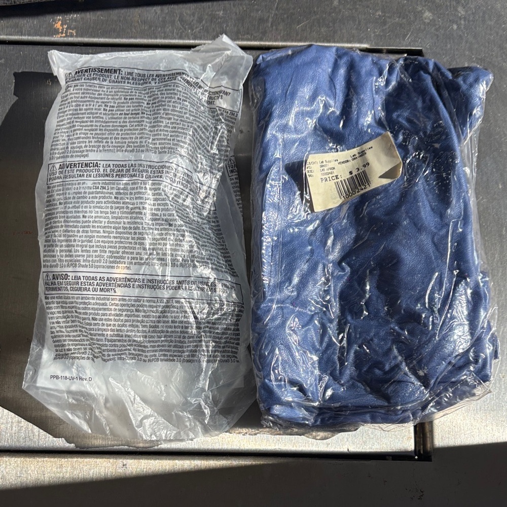 Unopened blue lab apron and lab glasses